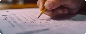 foco na mão de estudante fazendo o gabarito do enem 2026