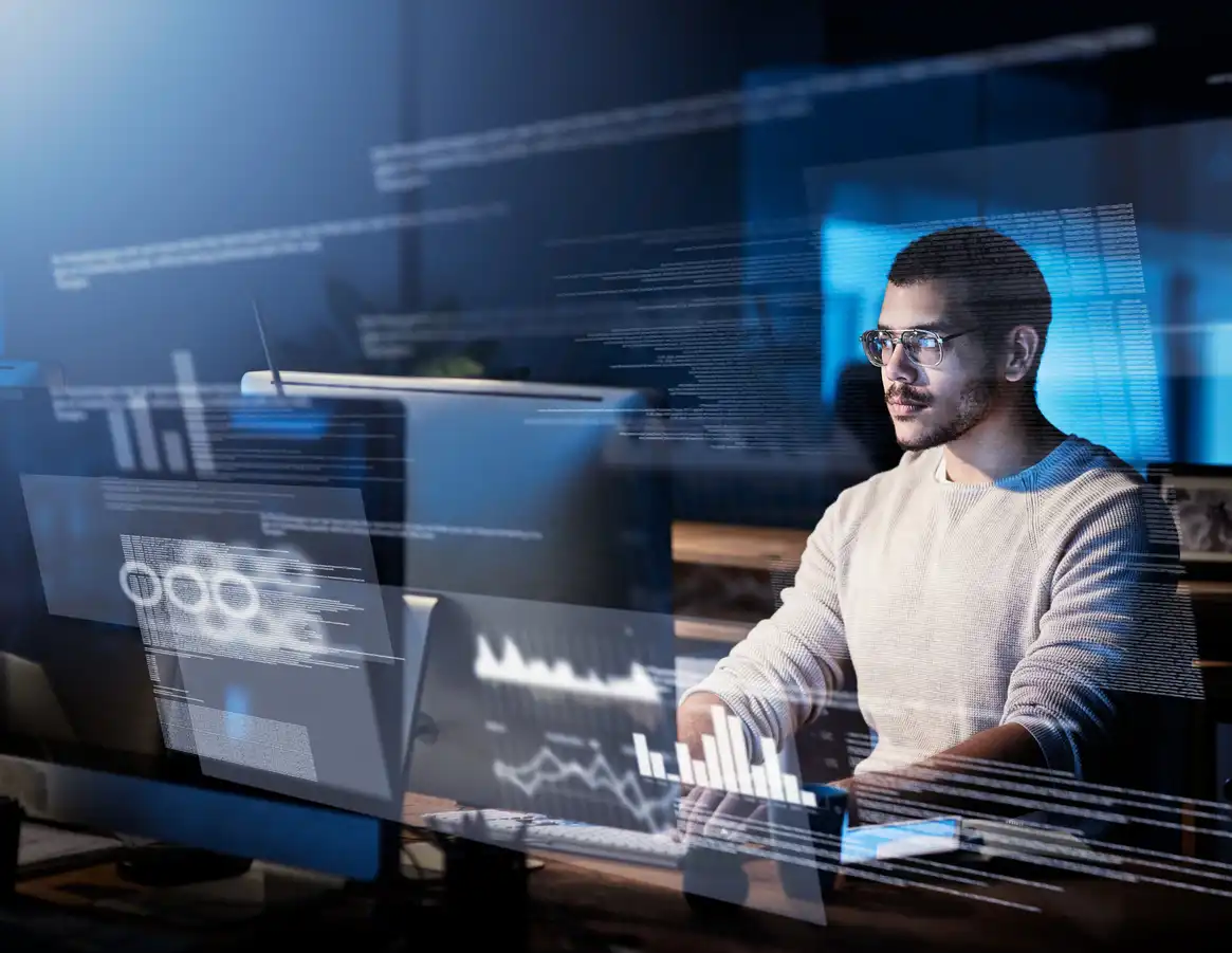 Homem trabalhando com análise de dados e tecnologia digital, com múltiplas telas exibindo gráficos e informações em ambiente moderno.