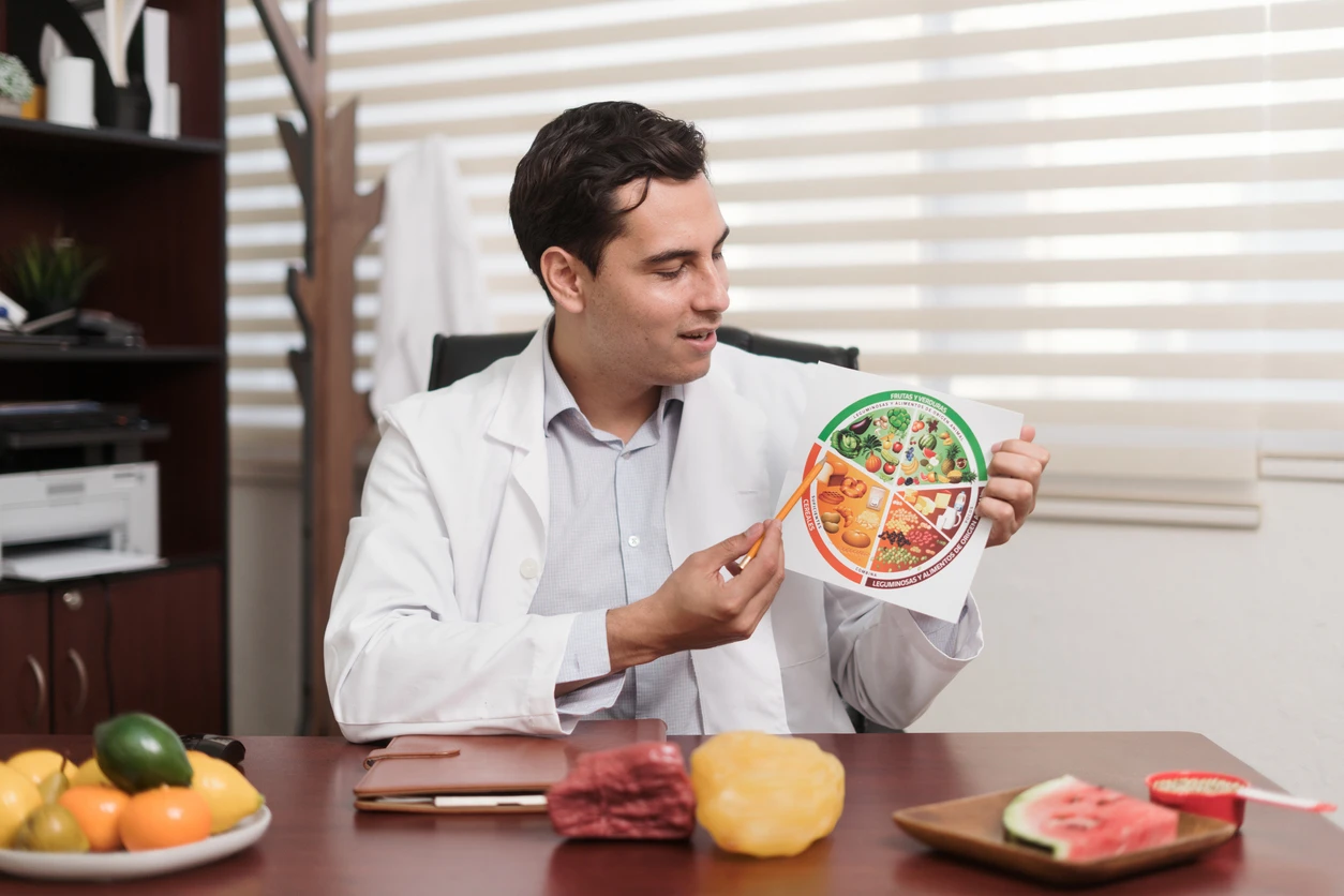 Profissional de saúde explicando uma dieta balanceada e os tipos de alimentos, incluindo frutas, verduras e proteínas, para promover uma alimentação saudável.
